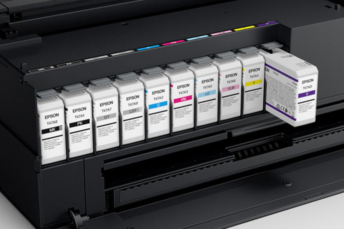 A row of Epson UltraChrome PRO10 ink cartridges installed inside the ink bay of a black Epson SureColor P900 printer.