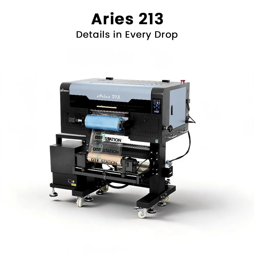 A large industrial DTF (Direct to Fabric) printer labeled 'Aries 213' with the text 'Details in Every Drop' above it, shown on a clean white background. The printer has a black and light gray body with a blue spool of material in the print bed.