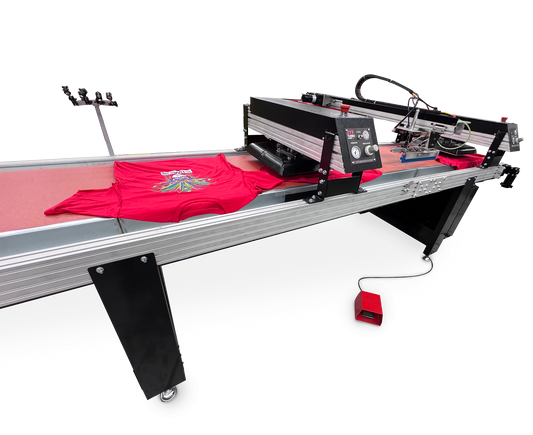 A large industrial flatbed t-shirt printing machine with a red control panel and a red t-shirt displayed on its bed, shown against a solid white background.