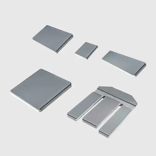 Six metallic silver-gray rectangular and L-shaped metal pieces arranged on a light gray background.