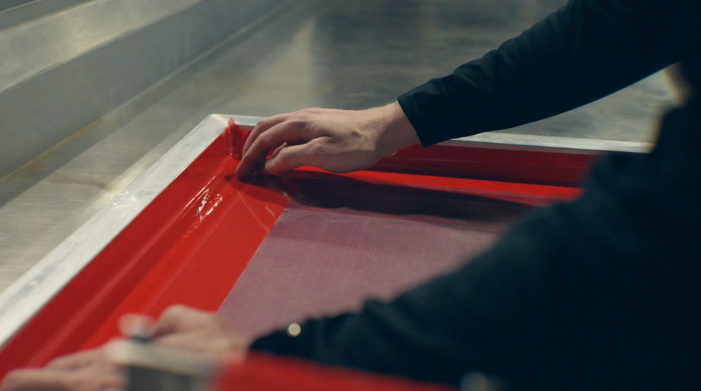 Person applying a red paint sample to a surface