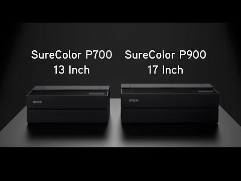 Two Epson desktop photo printers side-by-side on a dark surface: the SureColor P700 (13 Inch) on the left and the SureColor P900 (17 Inch) on the right, shown against a dark, minimalist background.